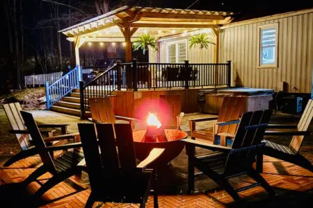 Night view of Copper Top Ridge with glowing fire pit, illuminated pergola, and warmly lit house exterior.