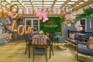 Bachelorette party in New Buffalo on the patio at Copper Top Ridge decorated with pink and rose gold balloons, a "Bride to Be" sign, and festive table settings.