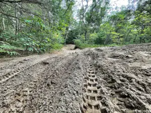 Muddy trail with deep tire ruts at Cedar Creek Motorsport Trail for off-roading in Southwest Michigan