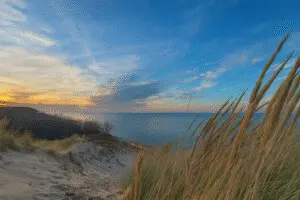 Weekend getaways from Indianapolis: Indiana Dunes dune overlook with beach grass and Lake Michigan at sunset.