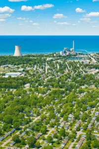 Discover Michigan City aerial summer view with Lake Michigan, lighthouse, cooling tower, and waterfront marina