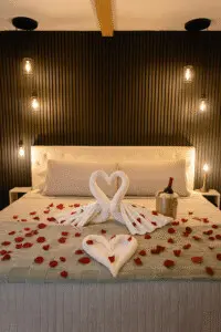 Lake Superior Suite at Copper Top Ridge prepared for romantic getaways near Chicago with heart-shaped towel display, rose petals, wine on ice, and soft Edison lighting.