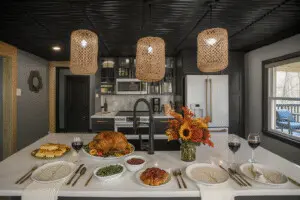 Thanksgiving vacation rental Michigan kitchen at Copper Top Ridge with roasted turkey, side dishes, wine, and autumn floral centerpiece on the island.