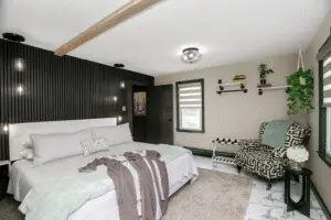 Luxury Vacation Rental in New Buffalo – Modern Bedroom Design Luxury Vacation Rental in New Buffalo featuring a modern cottage-style bedroom with king bed, designer chair, and elegant decor.