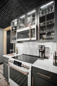 Modern kitchen at Copper Top Ridge vacation rental in Southwest Michigan with stove, microwave, coffee station, and glass cabinets — perfect for Thanksgiving cooking.