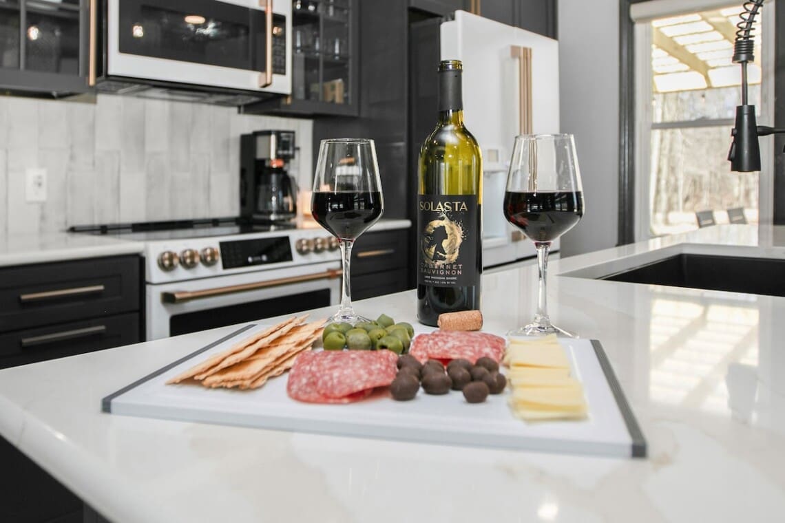 Charcuterie and wine setup inside a modern New Buffalo vacation rental kitchen