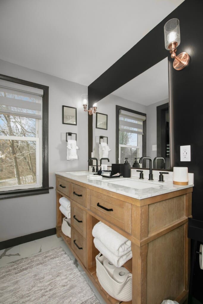 Modern double vanity bathroom with black fixtures and wood cabinetry at Copper Top Ridge