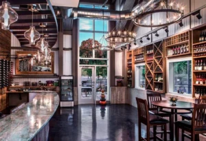 Dablon Winery & Vineyard | Things to Do in Southwest Michigan: Elegant tasting room and hillside vineyard with guests enjoying wine on the patio.