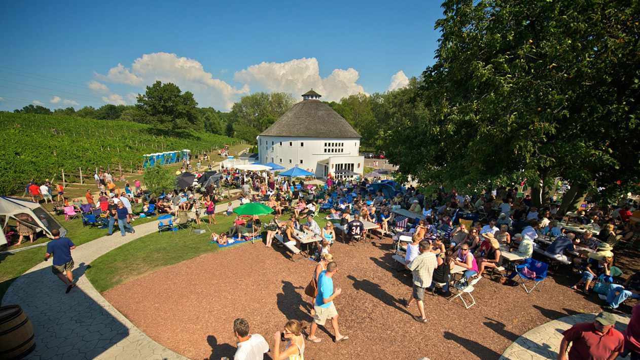 Round Barn Winery | Things to Do in Southwest Michigan: Guests enjoying wine tastings and live music in front of the iconic Amish-built round barn.