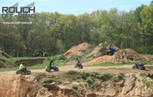 ATVs and side-by-sides riding dirt trails and jumps at Rouch Off-Road Park during off-roading in Southwest Michigan