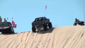 Modified El Camino, Chevy Silverado, and three-wheeler parked atop Test Hill at Silver Lake Sand Dunes during an off-roading adventure in Southwest Michigan
