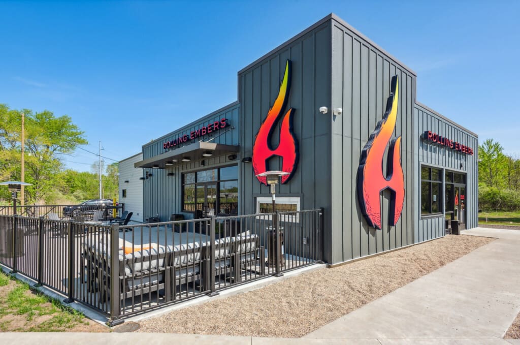 Modern exterior of Rolling Embers in New Buffalo with its flame logo and patio lounge, located right beside Four Winds Casino